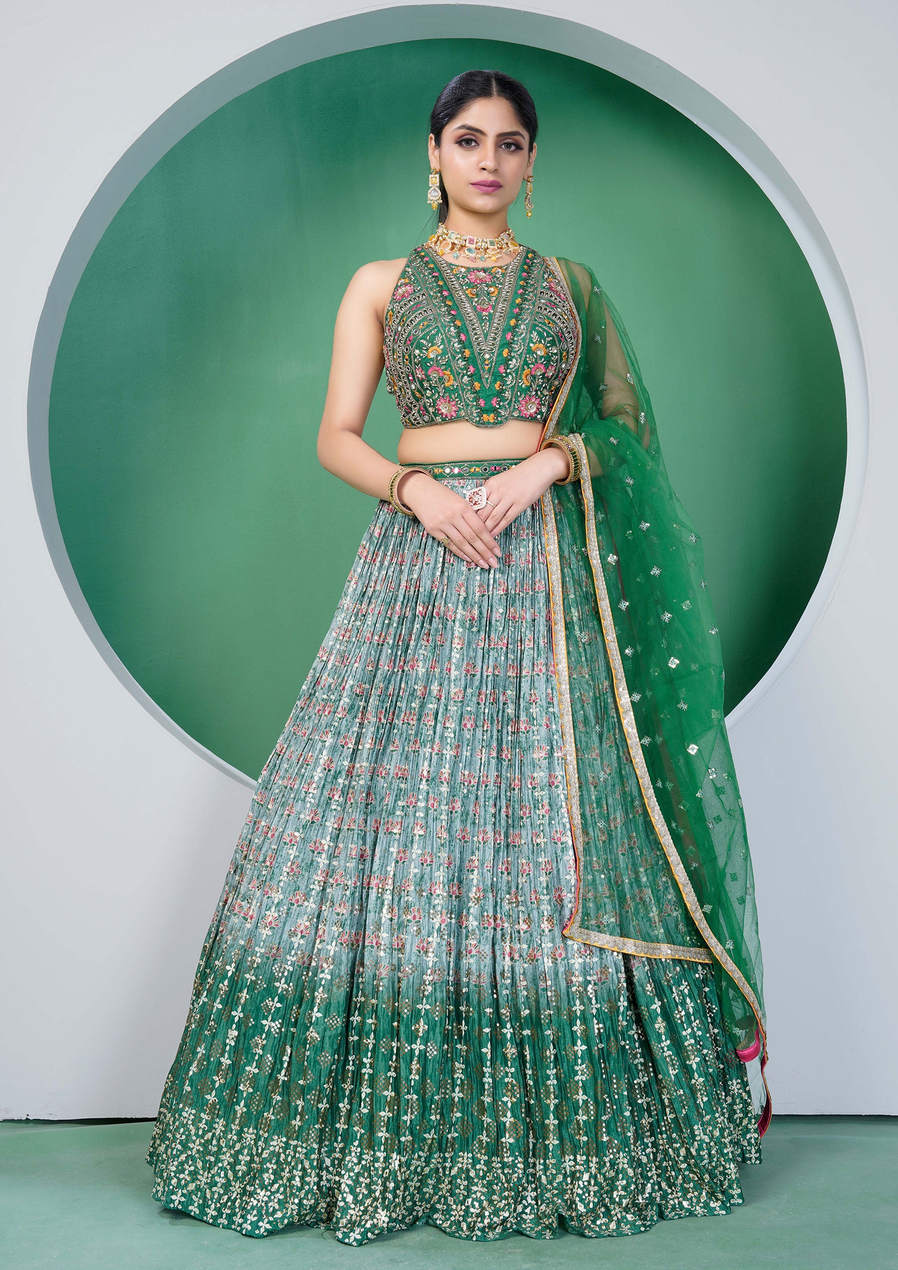 A beautiful green and gold embroidered lehenga choli, a traditional Indian outfit for women.