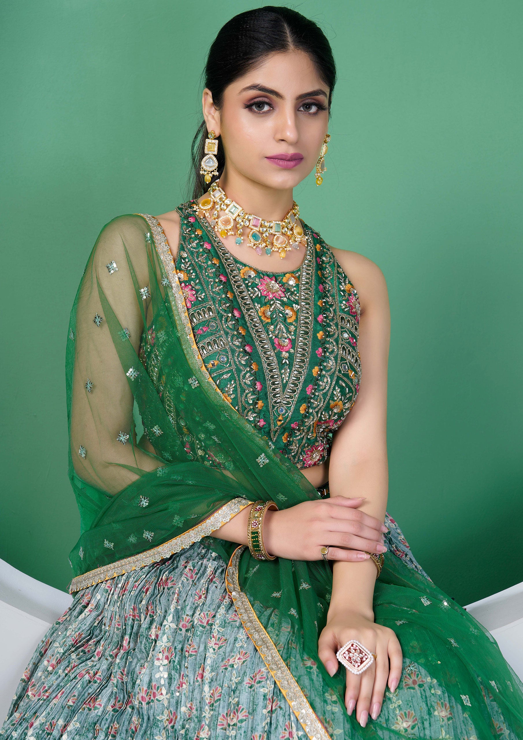 A beautiful green and gold embroidered lehenga choli, a traditional Indian outfit for women.