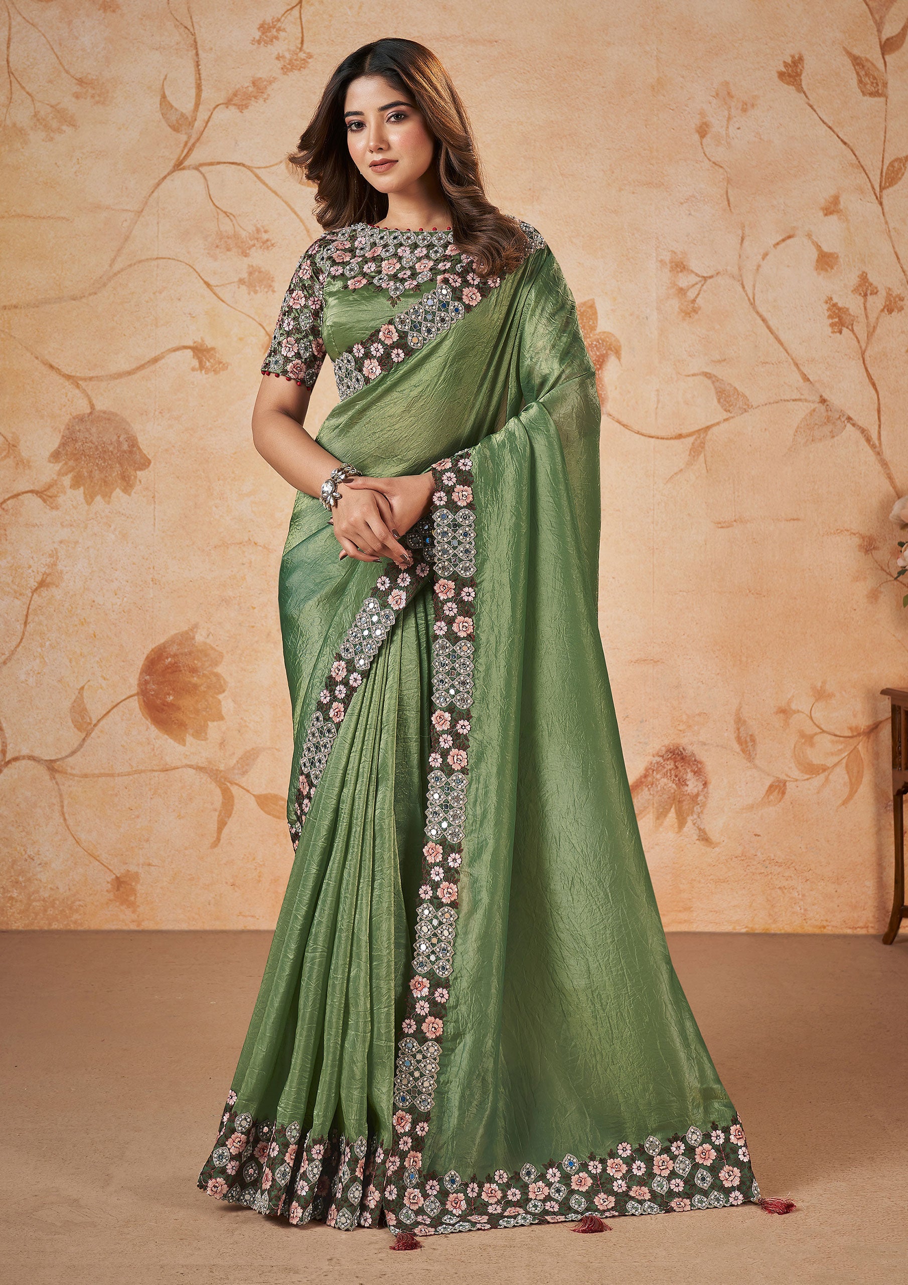 Green and brown printed silk saree with intricate floral patterns.