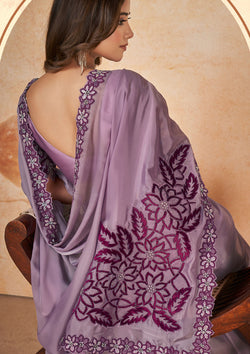 A purple embroidered saree with matching embroidered blouse, showcasing intricate designs and vibrant colors.