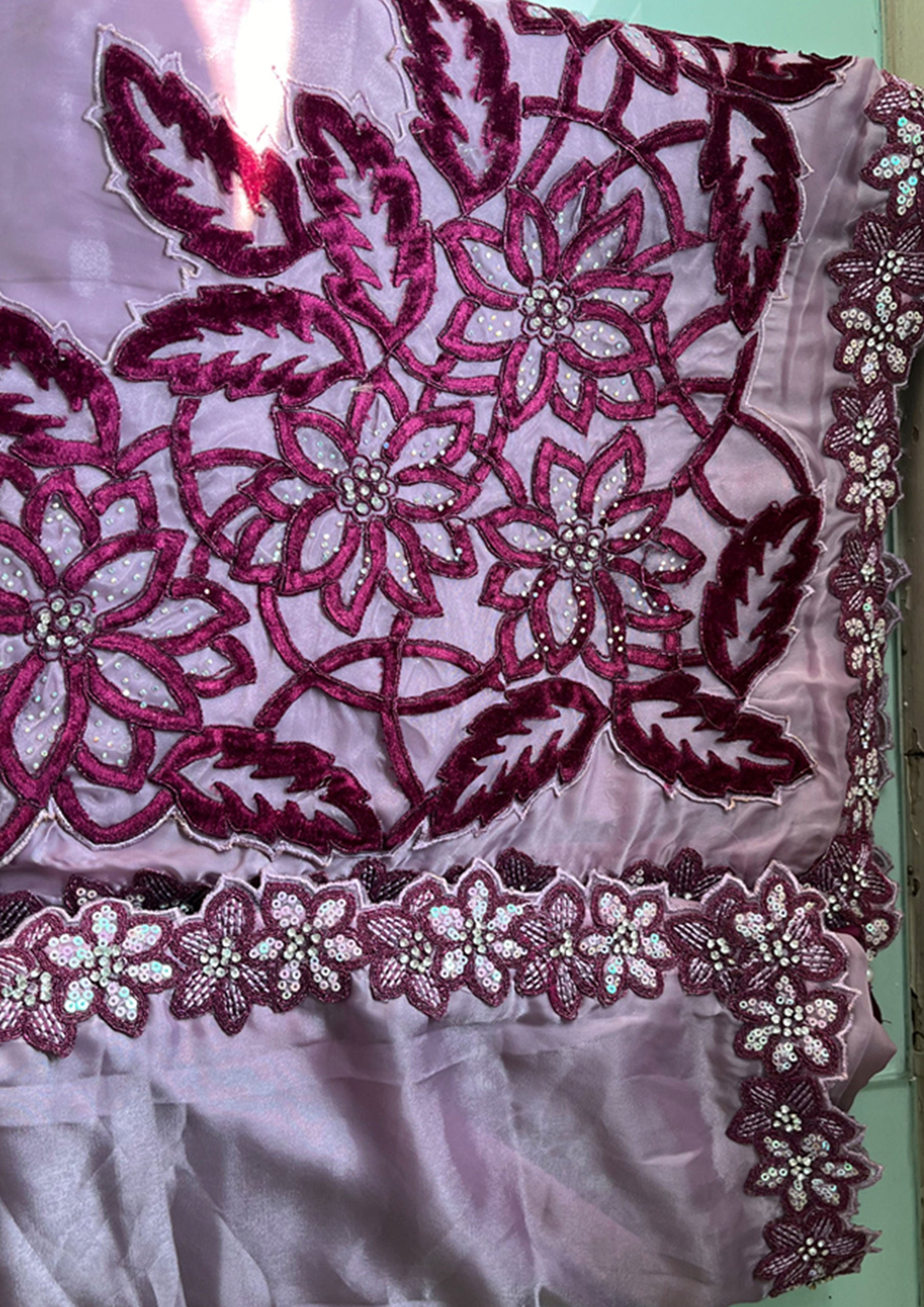 A purple embroidered saree with matching embroidered blouse, showcasing intricate designs and vibrant colors.