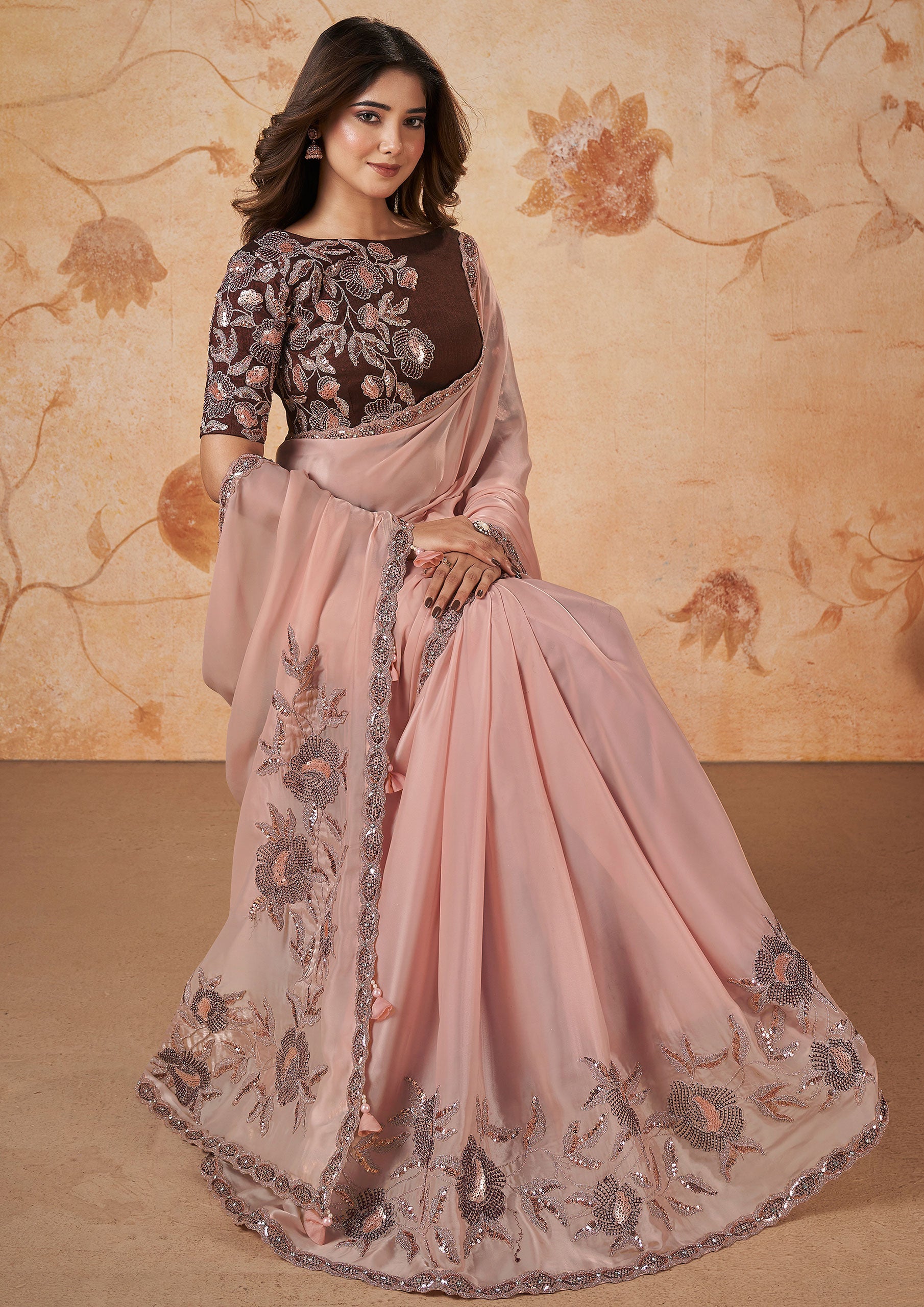 Pink georgette saree with intricate embroidery.