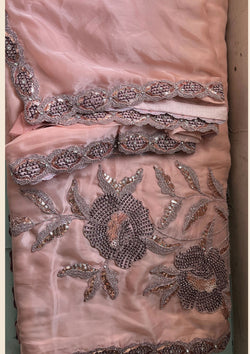 Pink georgette saree with intricate embroidery.