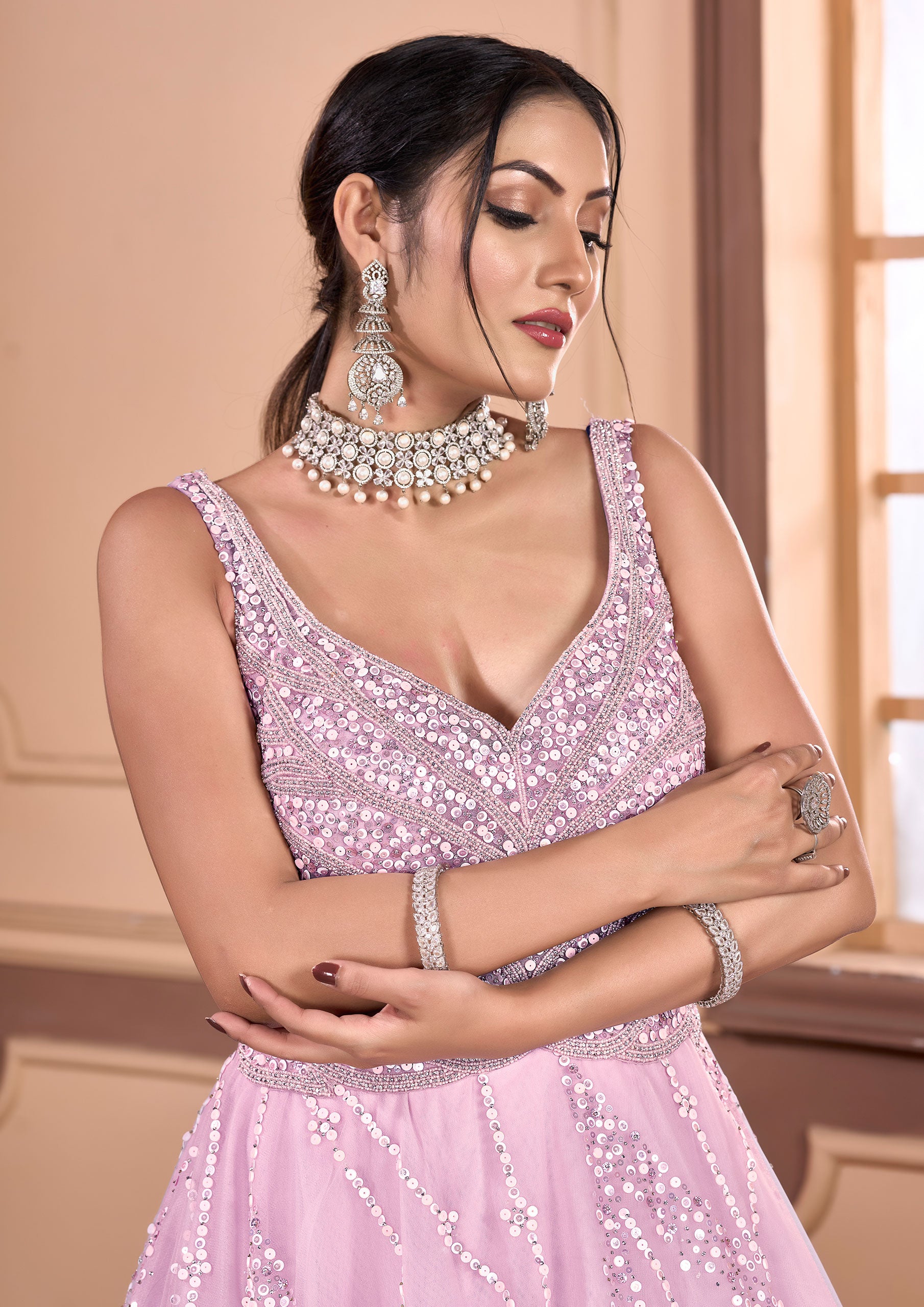 A woman in a pink gown and jewelry, looking elegant and sophisticated.