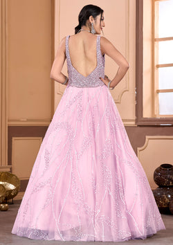 A woman in a pink gown and jewelry, looking elegant and sophisticated.