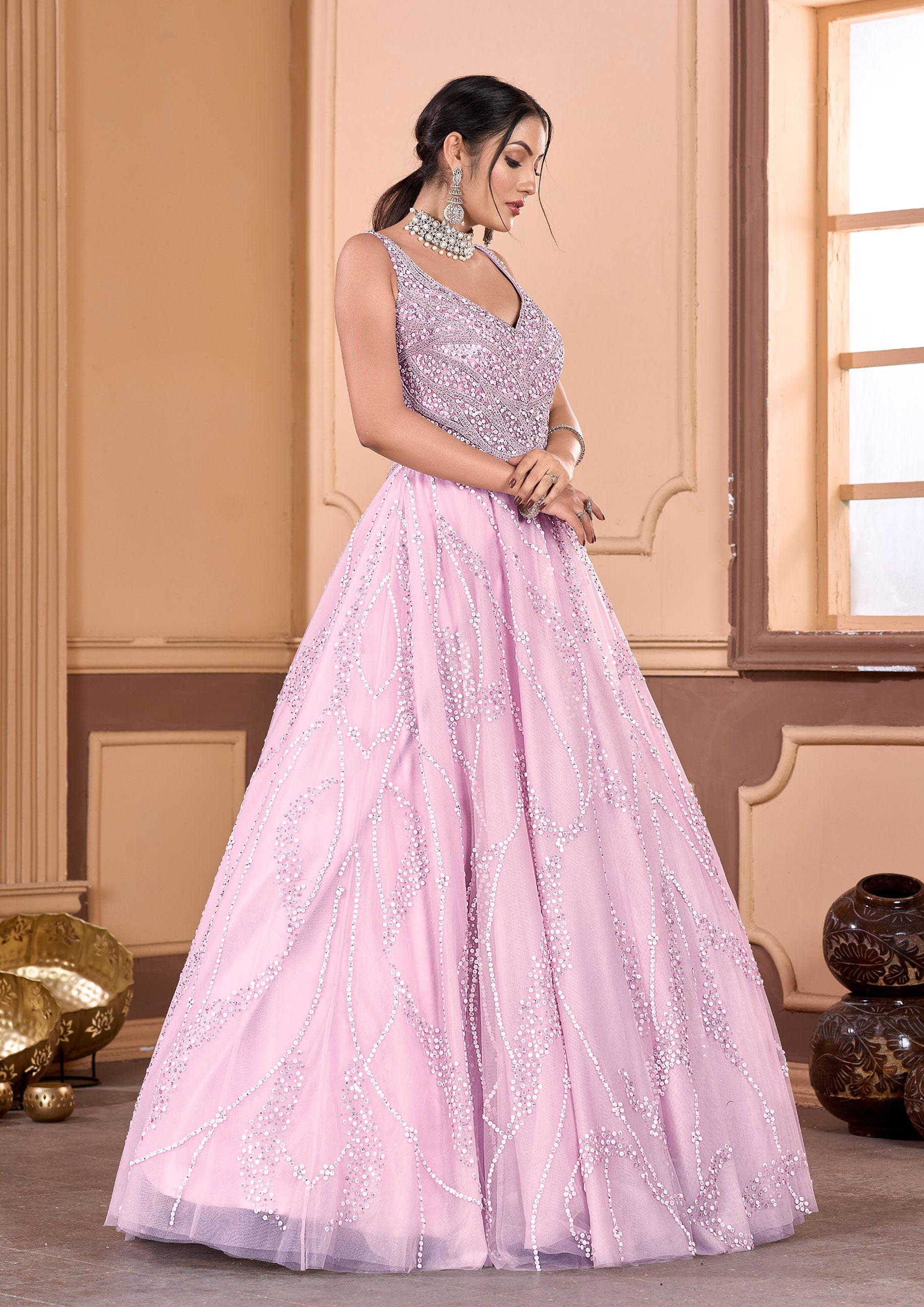 A woman in a pink gown and jewelry, looking elegant and sophisticated.