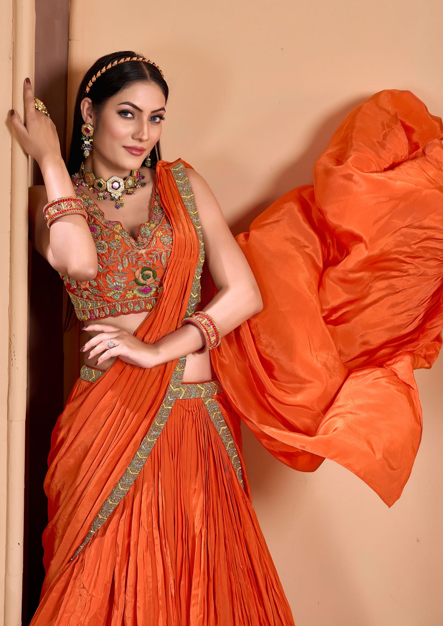 Woman from India dressed in bright orange sari, cultural outfit.