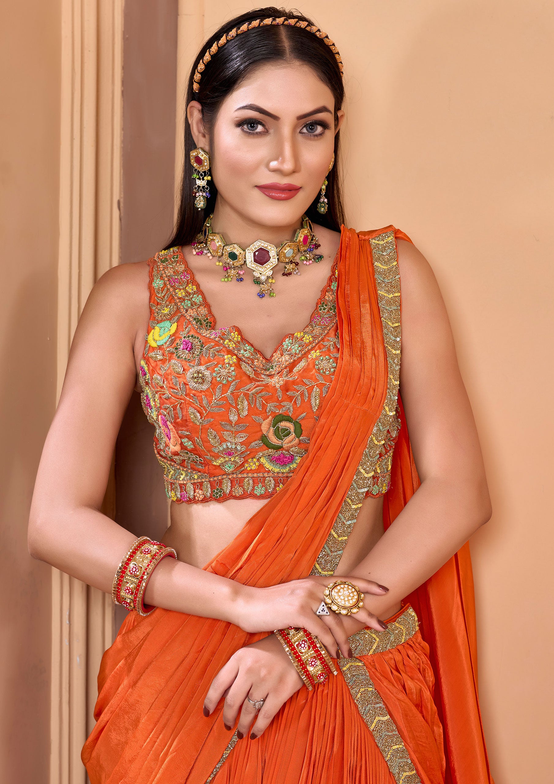 Woman from India dressed in bright orange sari, cultural outfit.