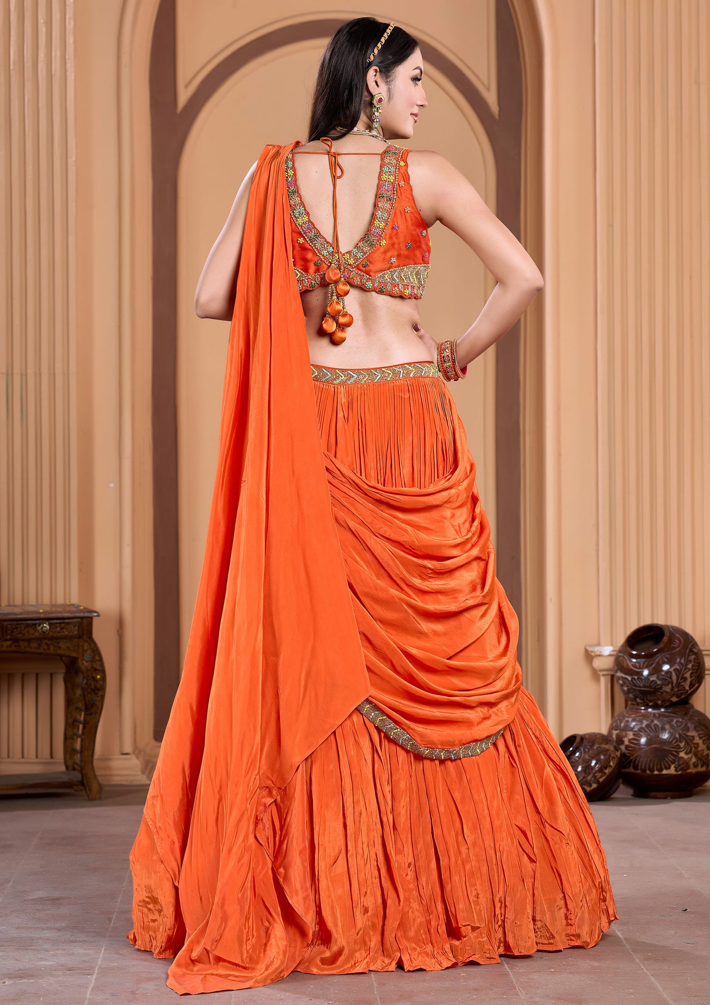 Woman from India dressed in bright orange sari, cultural outfit.