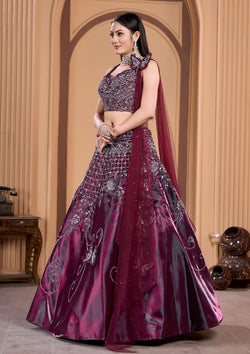 A stunning woman in a wine lehenga and matching blouse, adorned with elegant jewelry.