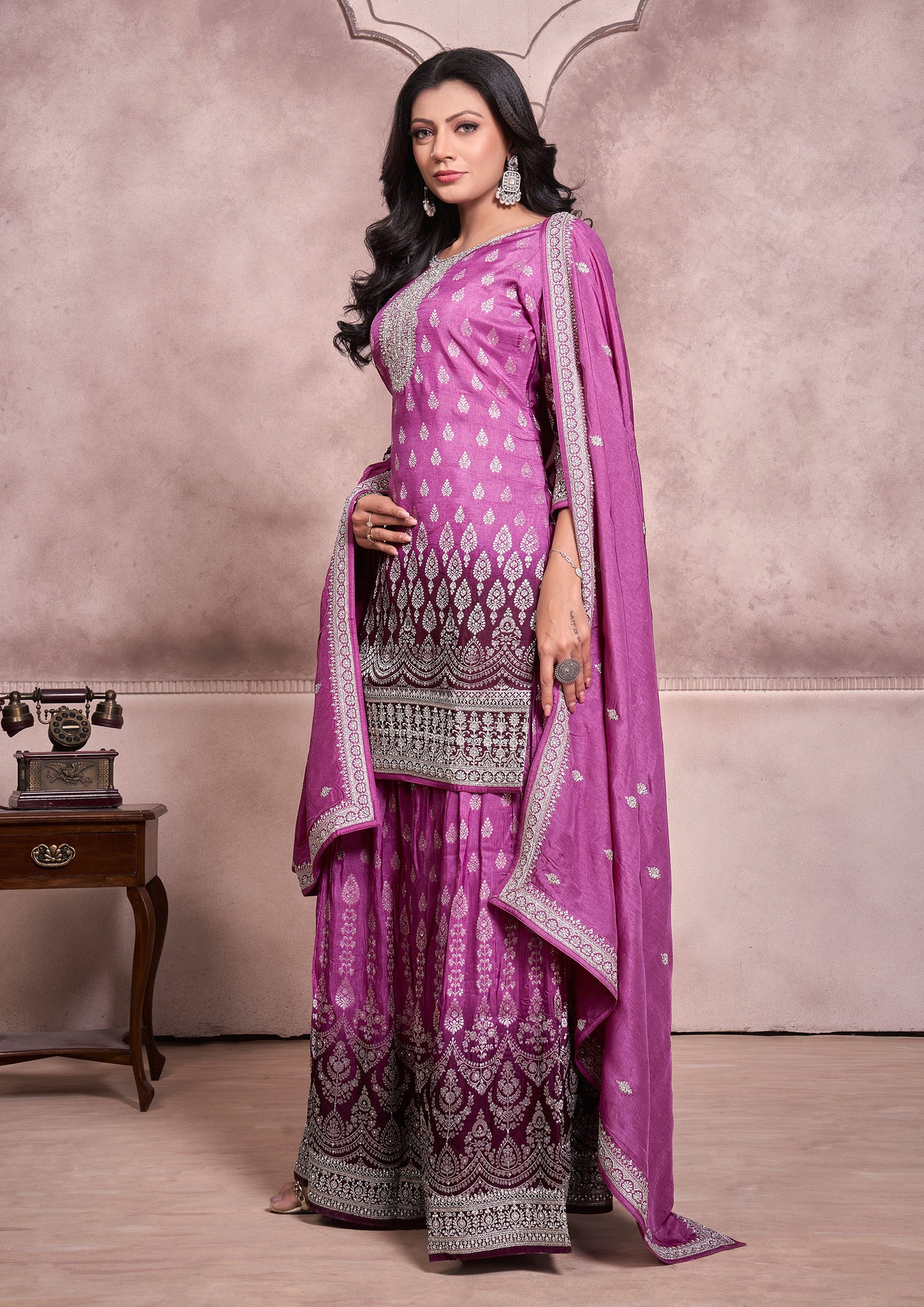 A purple embroidered suit with a matching dupatta, showcasing intricate designs and vibrant colors.