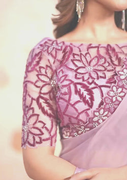 A purple embroidered saree with matching embroidered blouse, showcasing intricate designs and vibrant colors.