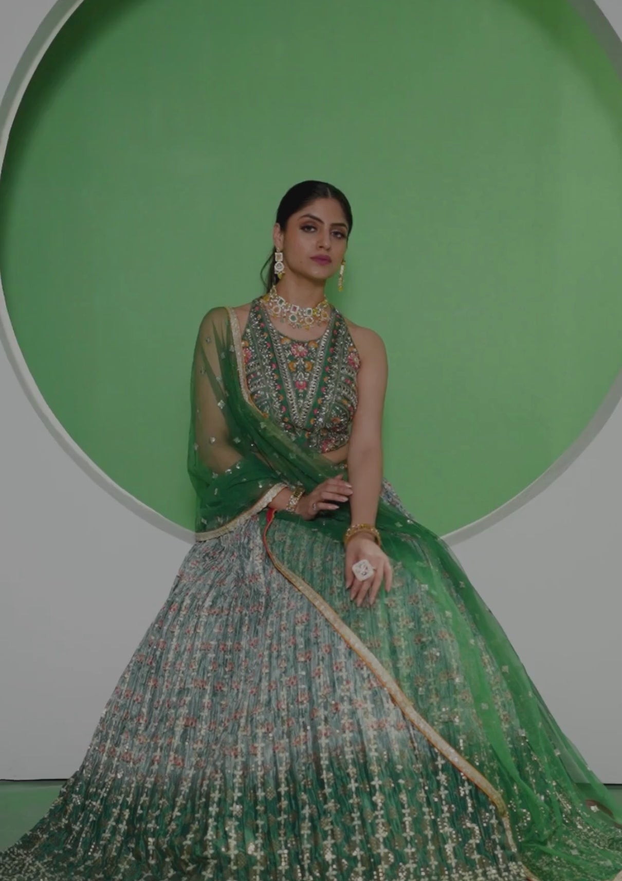 A beautiful green and gold embroidered lehenga choli, a traditional Indian outfit for women.