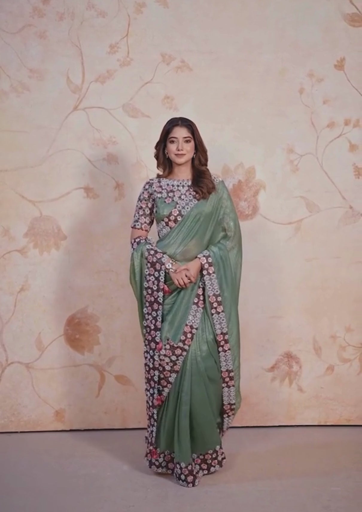 Green and brown printed silk saree with intricate floral patterns.